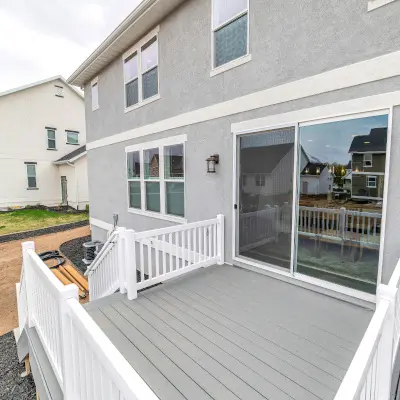 Light grey composite deck with white handrail and stairs leading to backyard