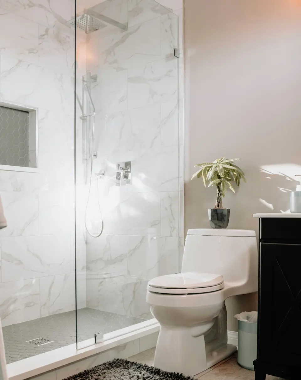 Black pergola with outdoor sofa on a paved patio and wooden privacy fence