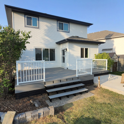Light grey composite deck with white handrail and stairs leading to backyard