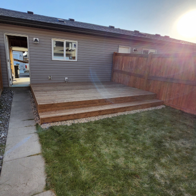 Pressure treated deck with skirting, stairs, handrail, and black metal pickets